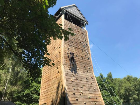 Someone climbing up a climbing wall