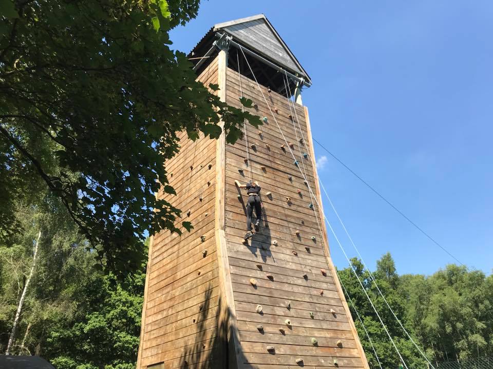 Someone climbing up a climbing wall
