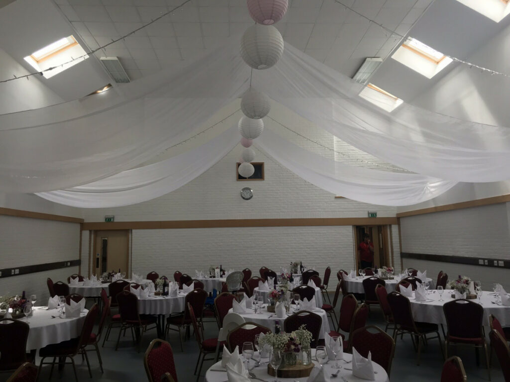 A room with several tables set up for dinner