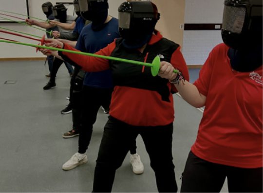 People holding plastic swords