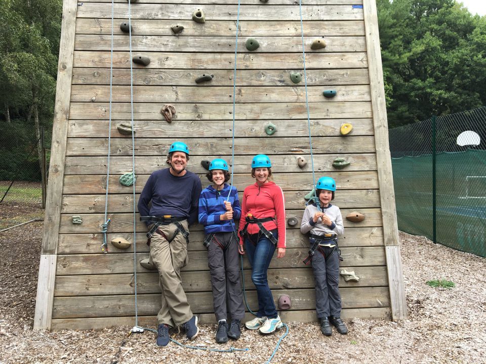 A group of people standing at the bottom of a climbing wall